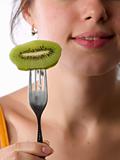 Beautiful lady eats kiwi