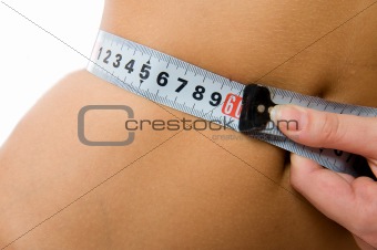 Close-up sexy woman measuring her waist with a measuring tape. 