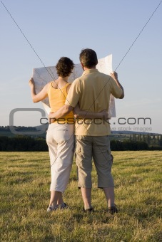 Couple with map in a meadow