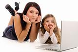 Mother teaching her daughter how to use laptop