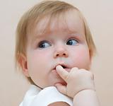 Baby with finger in mouth, looking backward