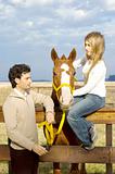 Young couple relaxing with their horse