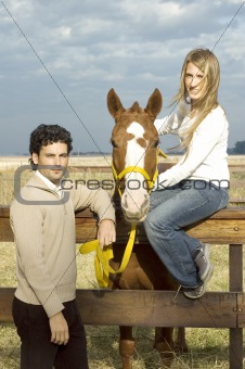 Young couple posing with their horse