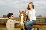 Young couple relaxing with their horse