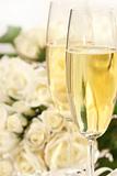 Close-up of champagne glasses with a bouquet of roses