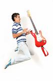Teen jumping with guitar