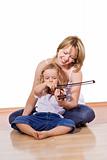 Woman teaching little girl to play the violin