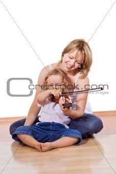 Woman teaching little girl to play the violin