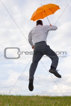Happy businessman with orange umbrella