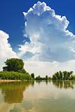 A cloud against a backdrop of blue sky. Landscape by the river